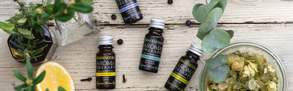Esenciálne oleje Manufaktura na drevenom podklade s citrusmi, chmeľom, borievkou a bylinkami.