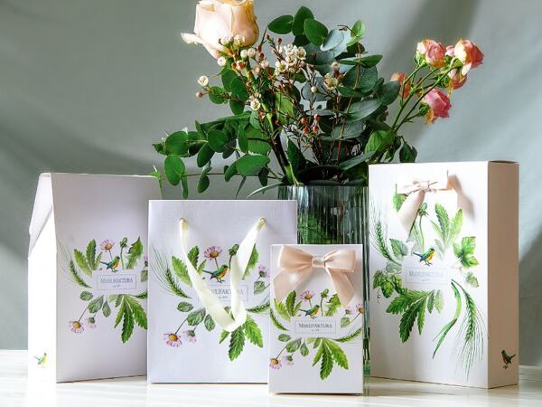 Darčekové tašky Manufaktura s prírodnými motívmi a kvetinovou dekoráciou vo váze.