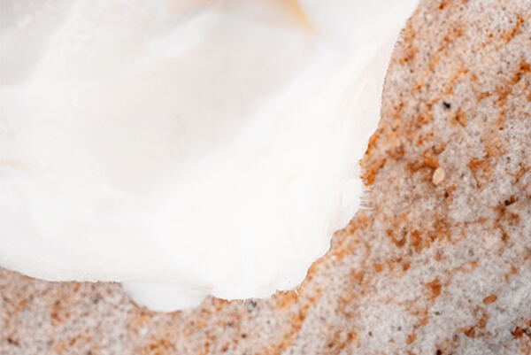 Detail struktury bambuckého másla na přírodní textuře.