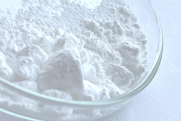 Biely prášok DHA v laboratórnej miske ako prírodná samoopaľovacia zložka.