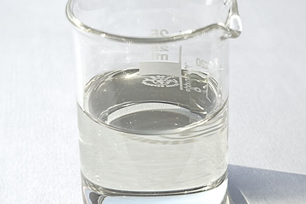 Priehľadný extrakt z morskej riasy Laminaria Ochroleuca v sklenenej laboratórnej nádobe.