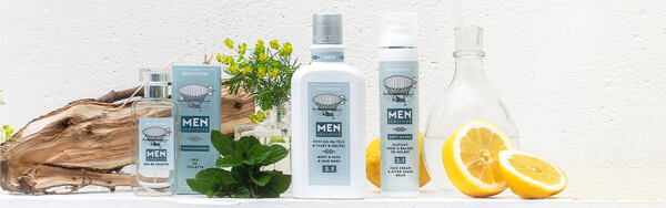 Kozmetické produkty Manufaktura Men SENSITIVE s citrónmi, bylinkami a drevom na svetlom pozadí.